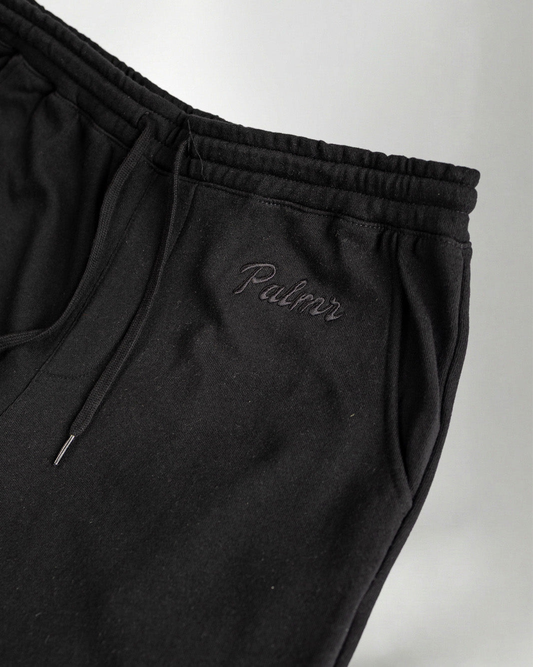Black pants with the Palmr logo embroidery in jogger style