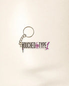 Keychain with 'Touched by Type 1' text on a light background
