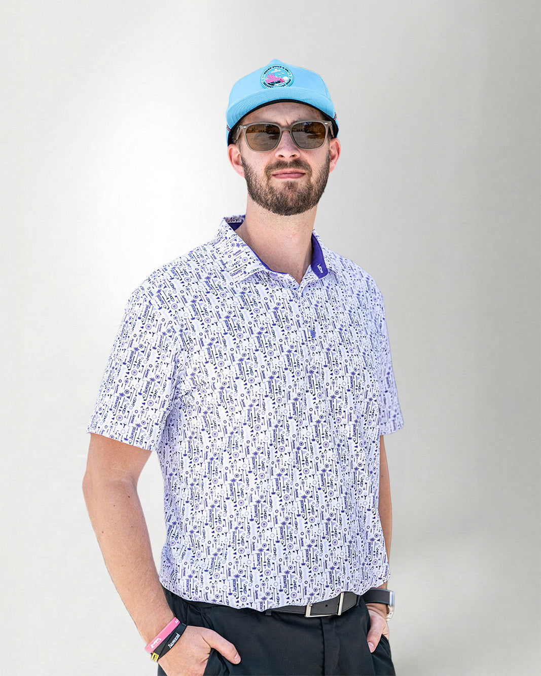 Man wearing a patterned shirt and cap against a plain background