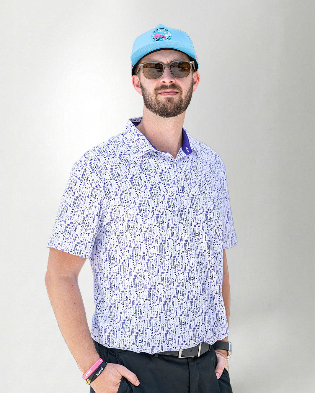 Man wearing a patterned shirt and cap against a plain background