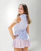 Woman wearing a patterned sleeveless polo and a skirt