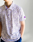 Child wearing a patterned shirt and blue cap against a plain background
