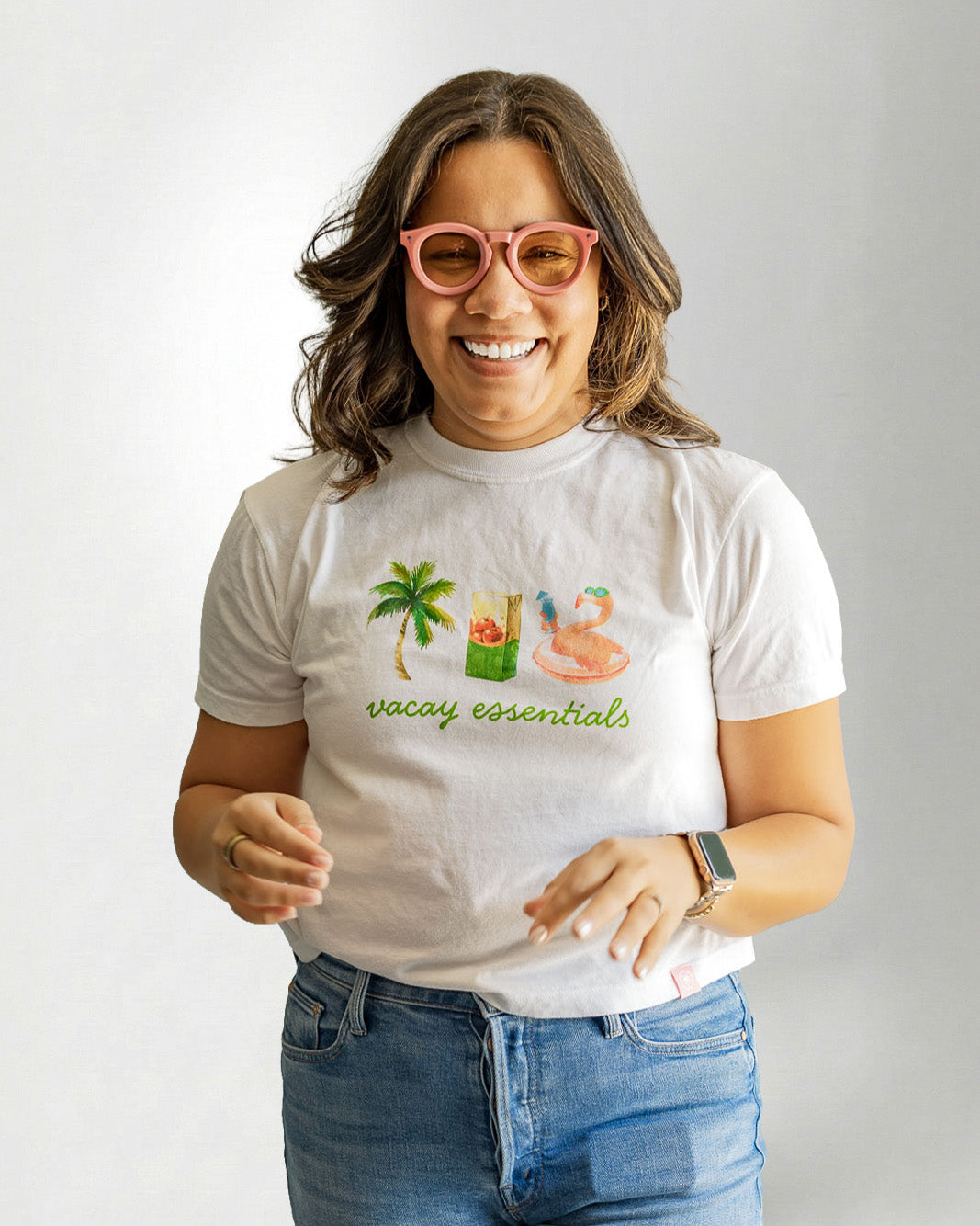 Woman wearing a white tee showcasing a "Palmr" branding with vacay essentials objects.