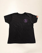 Black t-shirt with a purple logo on a beige background
