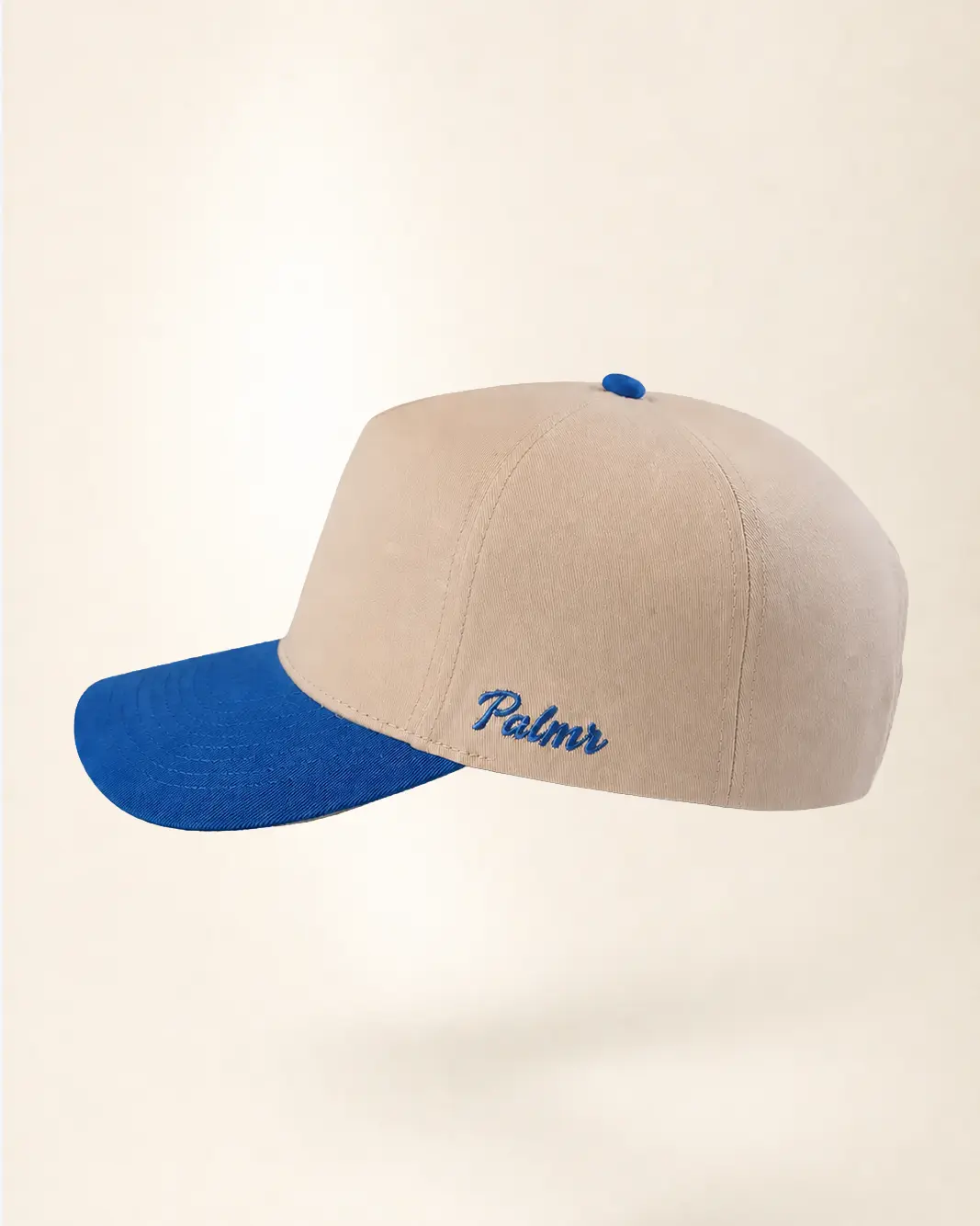 A beige baseball cap with a bright blue curved brim, blue button, and blue embroidered script text reading 'Palmr' on the side, shown against a plain light beige background.