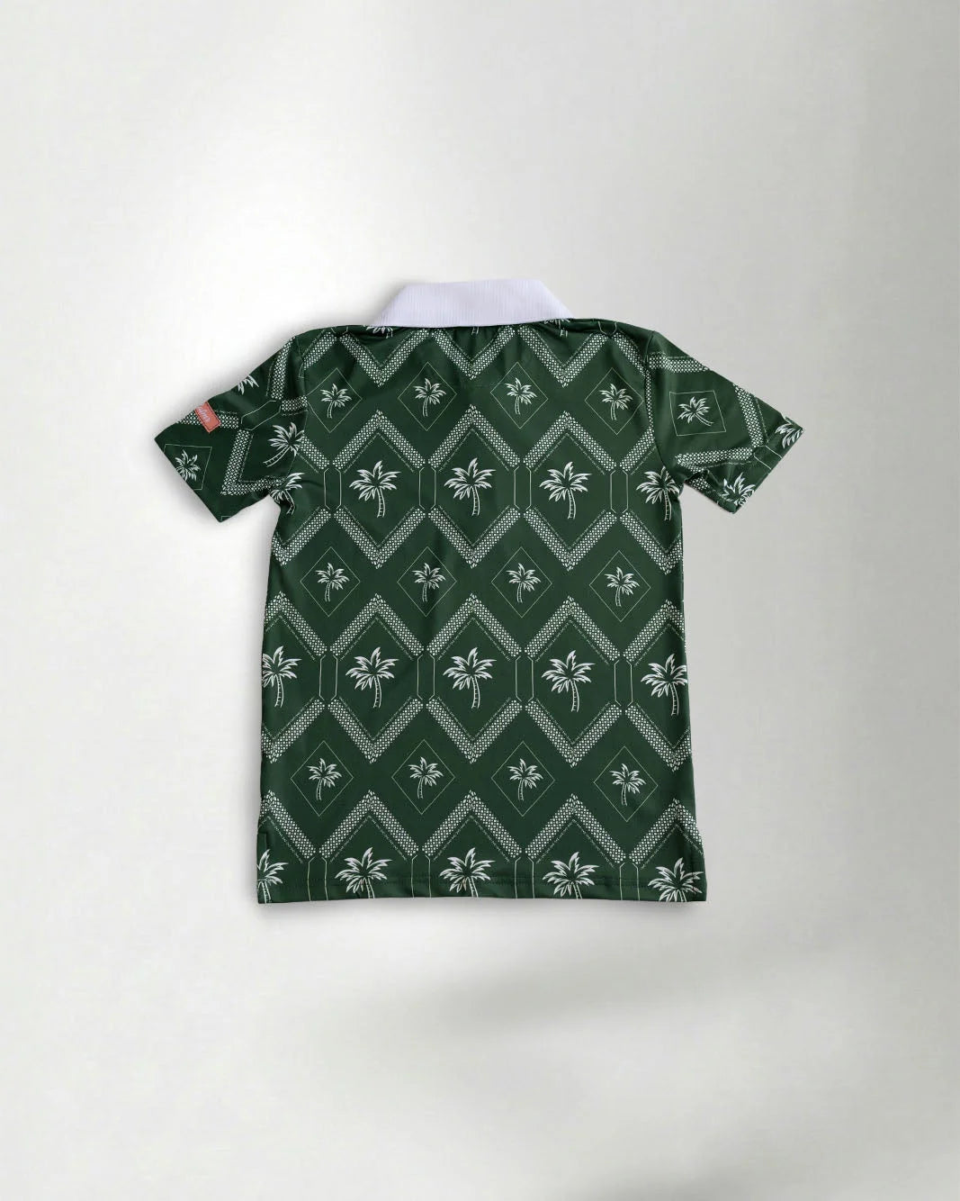 Green polo shirt with contrasting white neck showcasing a palm pattern against a grey background