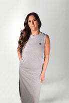 Woman wearing a gray sleeveless dress against a white background