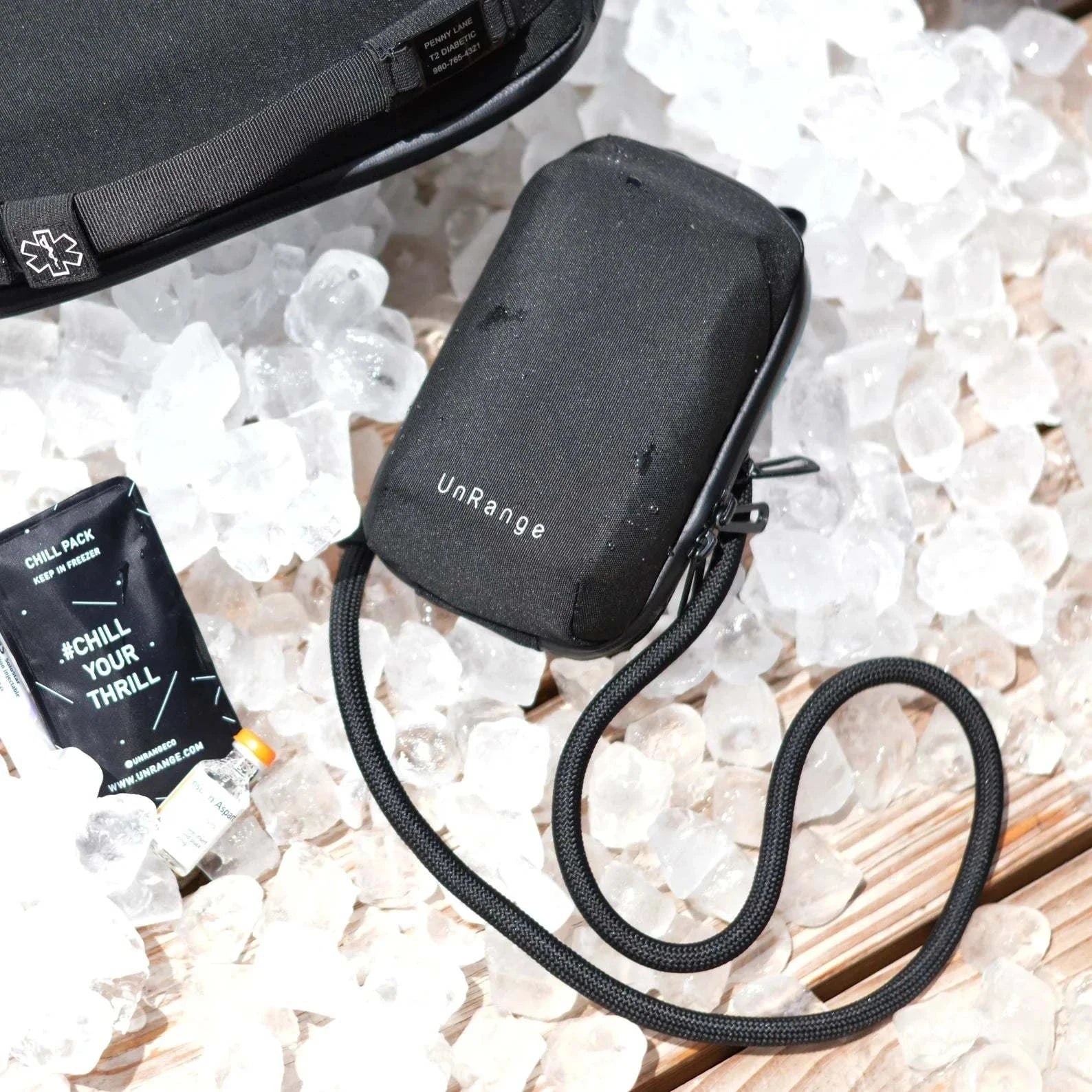 Compact insulated crossbody bag with nylon strap, carabiner clips, and chill pack for diabetes medication storage