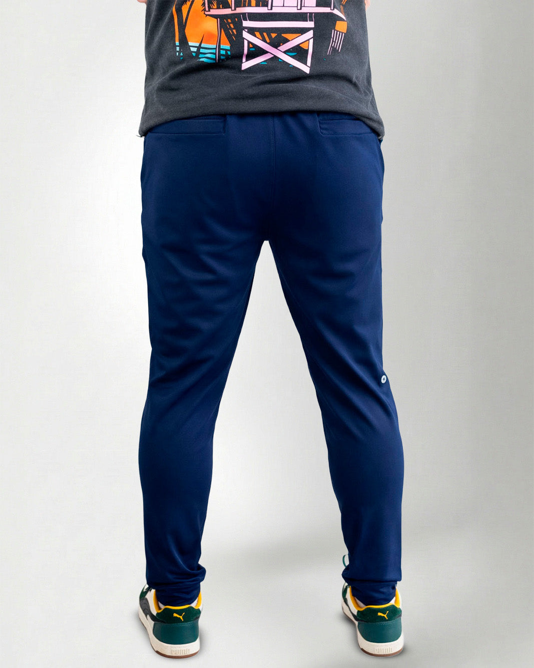 Person wearing blue pants and green sneakers on a white background