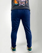 Person wearing blue pants and green sneakers on a white background