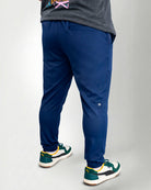 Person wearing blue pants and green sneakers on a white background