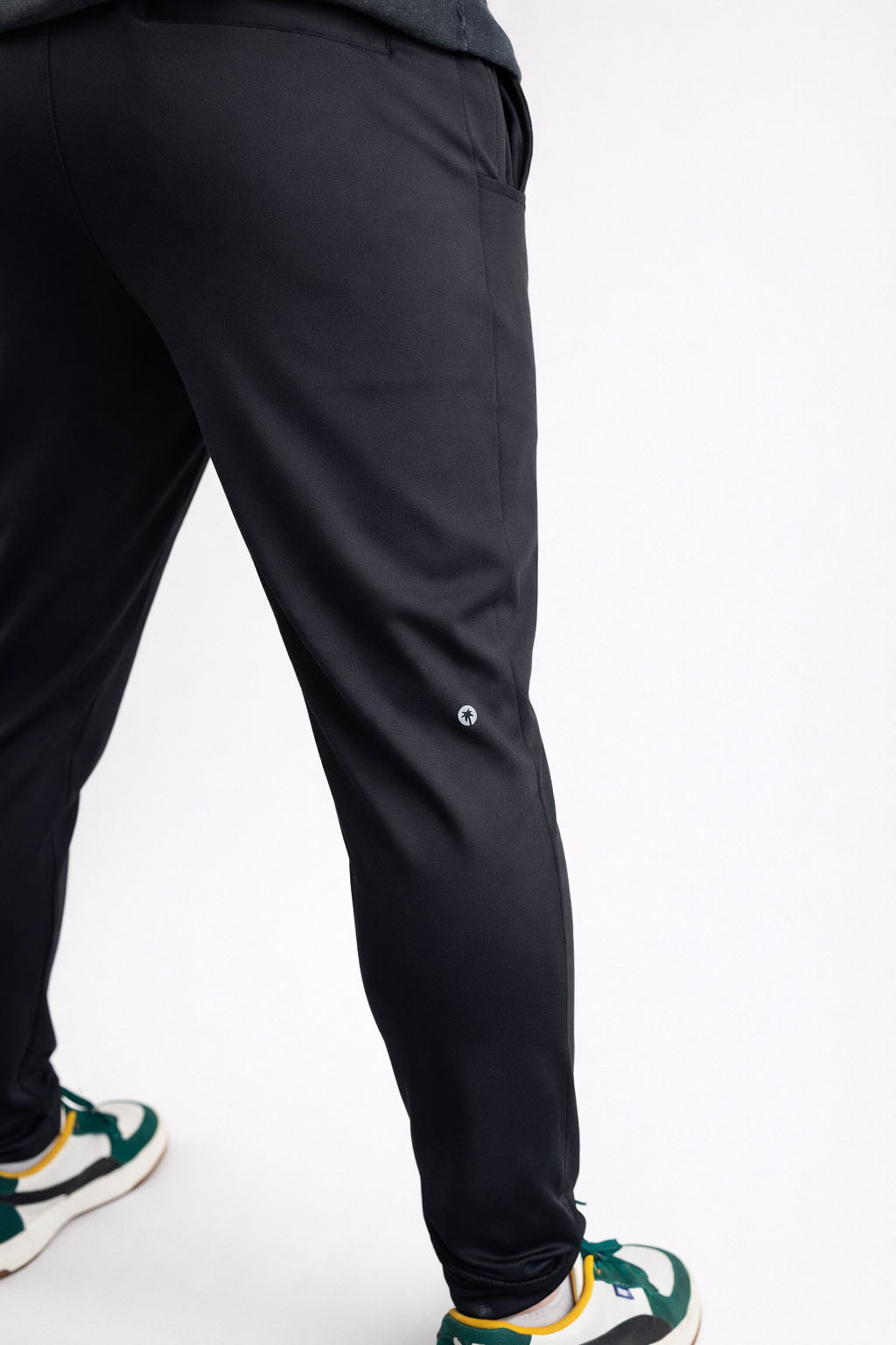 Black pants worn by a person on a white background