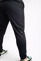 Black pants worn by a person on a white background