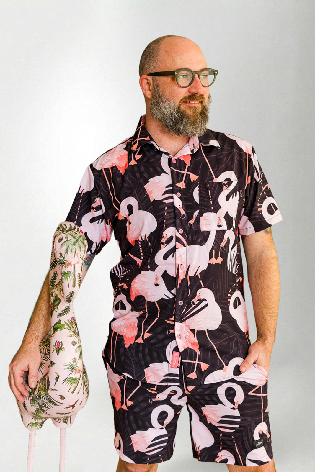 Man wearing a black floral patterned romper with a plain background