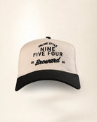 A baseball cap with a cream-colored crown and a black brim, featuring black embroidered text on the front that reads 'PALMR STYLE NINE FIVE FOUR Broward 2026'.