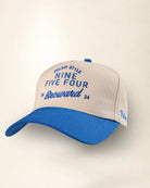 A baseball cap with an off-white crown and a bright blue brim, featuring blue embroidered text on the front and side.