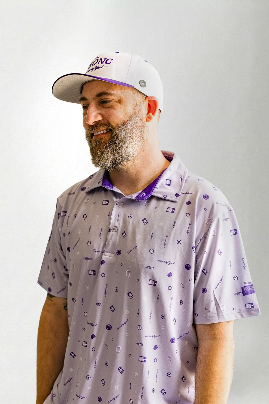 Man wearing a patterned shirt and cap against a plain background