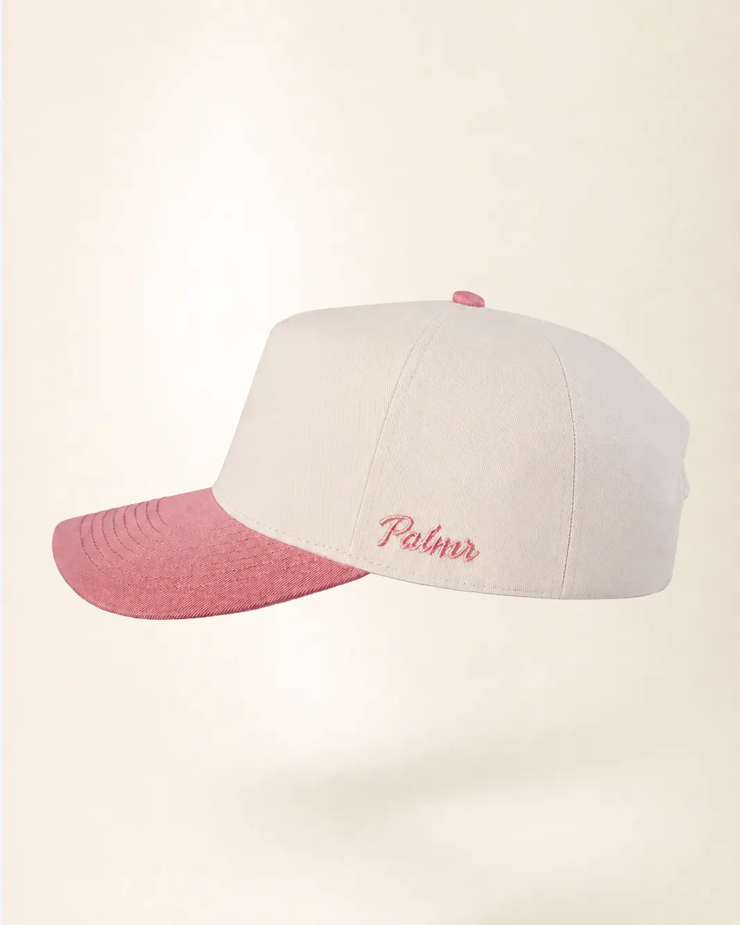 A structured baseball cap with a white crown and a contrasting pink brim, featuring the name 'Palmr' embroidered in pink script on the side.