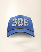 The 386 Signature Hat (Blue), front view: white raised 386 with small palm print on a blue crown, black and white rope along the brim.