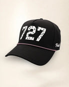 The 727 Signature Hat (Black), three-quarter view: white raised 727 with small palm print on a black rope snapback, pink and white rope, white Palmr script.
