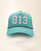 The 813 Signature Hat (Teal), front view: white raised 813 with small palm print on a teal crown, pink and black rope along the brim.