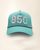The 850 Signature Hat (Teal), front view: white raised 850 with small palm print on a teal crown, pink and black rope along the brim.