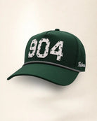 The 904 Signature Hat (Green), three-quarter view: white raised 904 with small palm print on a green rope snapback, black and white rope, white Palmr script.