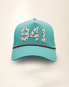 The 941 Signature Hat (Teal), front view: white raised 941 with small palm print on a teal crown, pink and black rope along the brim.